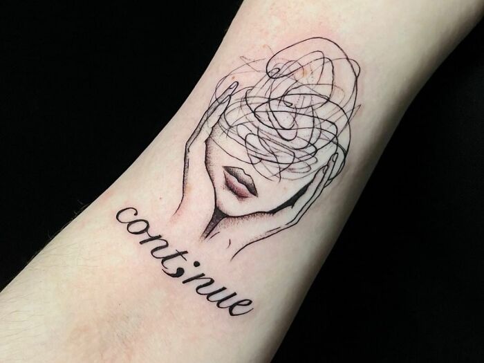 Mental health tattoo on forearm, featuring a sketch of a face with “continue” text symbolizing healing and perseverance.