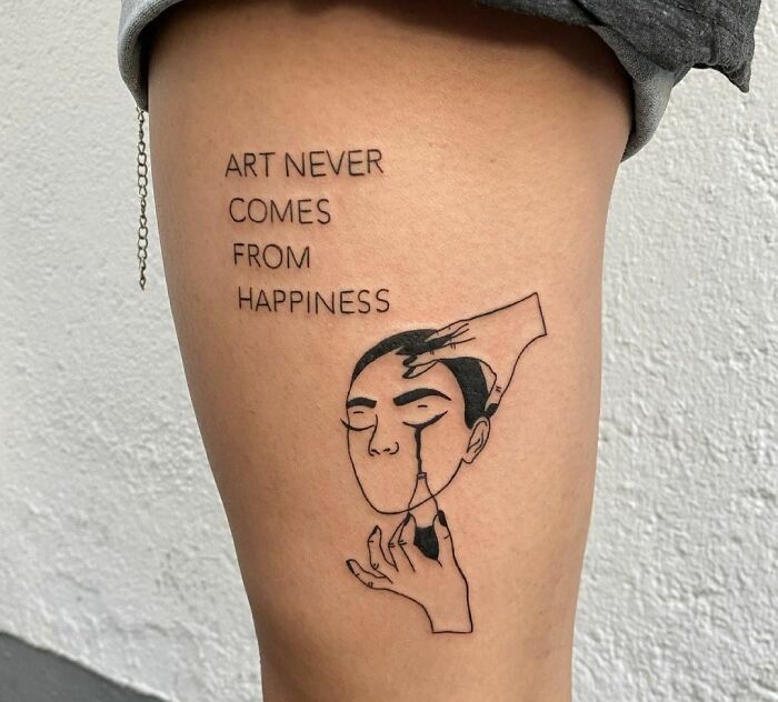 Tattoo of a face being sketched with text "Art never comes from happiness" related to mental health healing.