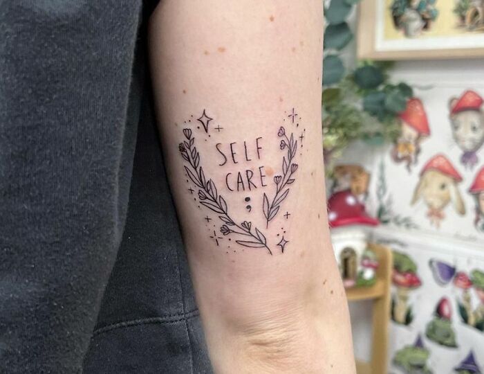 Arm tattoo with floral design and "Self Care" text, symbolizing powerful mental health themes.