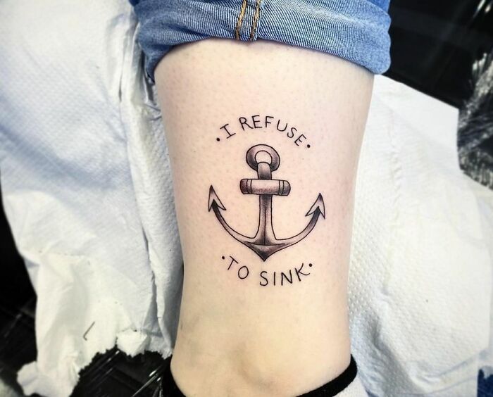 Anchor tattoo on thigh with words "I refuse to sink," symbolizing powerful mental health and resilience.