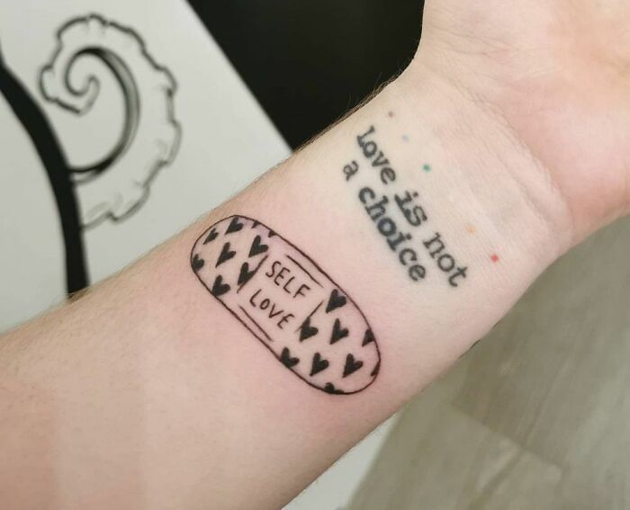 Arm tattoo with a band-aid design reading "self love" and text "love is not a choice," symbolizing mental health healing.