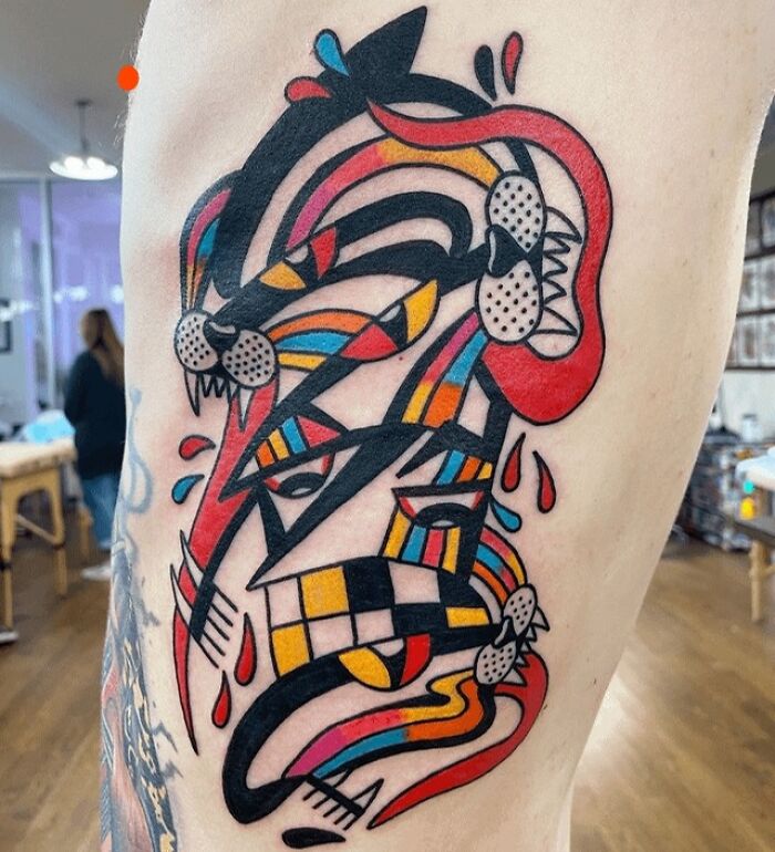 Colorful abstract tattoo showcasing artistry and self-expression with bold geometric and tribal patterns.