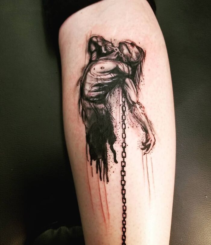 Detailed black ink mental health tattoo of a chained figure on an arm.