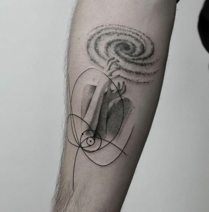 Abstract mental health tattoo featuring hands holding a swirling galaxy on an arm, symbolizing healing and inner peace.