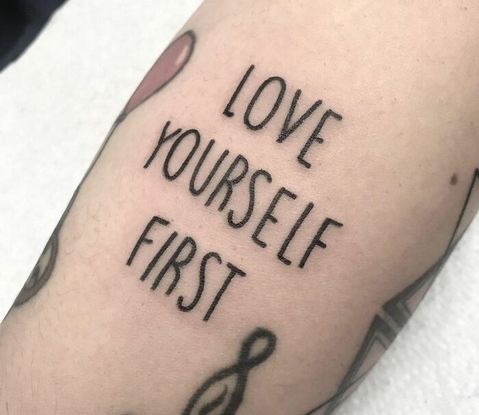 Tattoo on arm with the words "Love Yourself First," symbolizing powerful mental health.