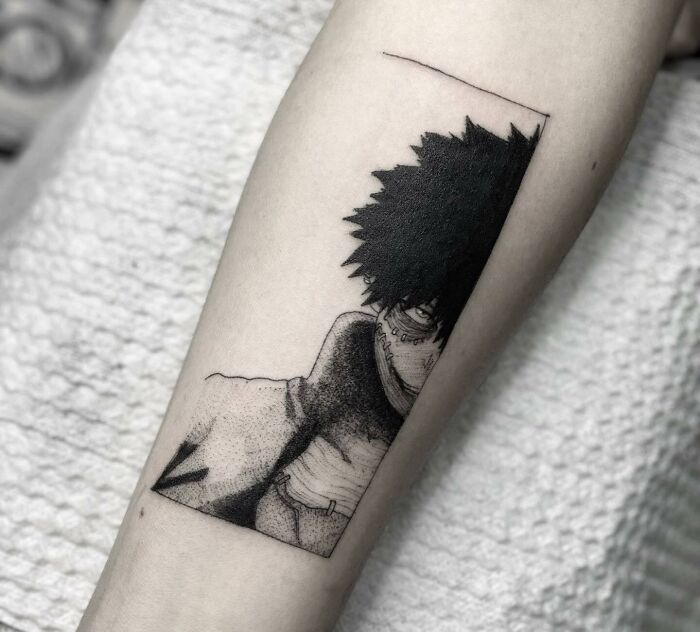 Anime tattoo featuring a mysterious character with spiky hair and a mask on an arm.