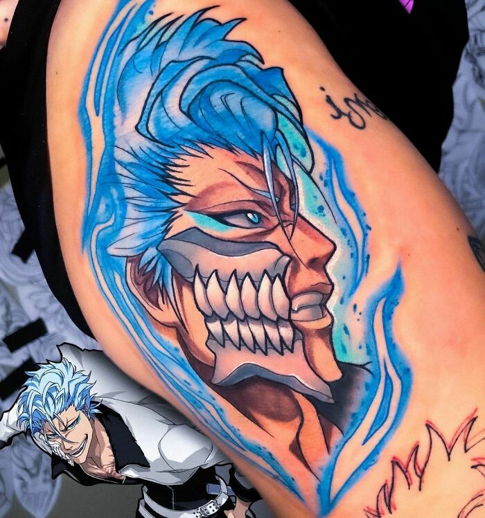 Anime tattoo featuring a vibrant, detailed character with blue hair and fierce expression on an arm.