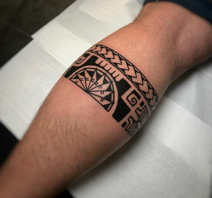 Close-up of a tribal tattoo design on a person's leg.