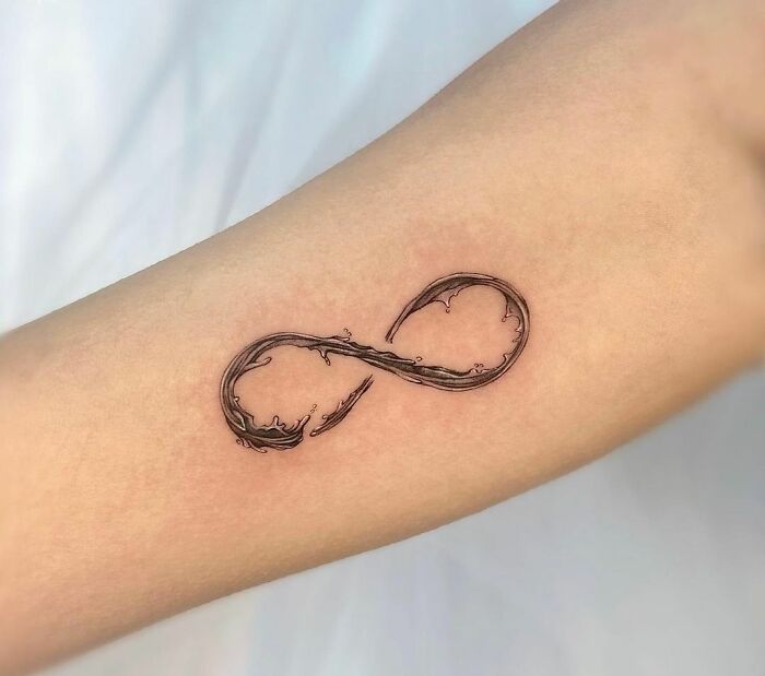 Infinity tattoo on forearm, showcasing eternal creativity with a flowing design.