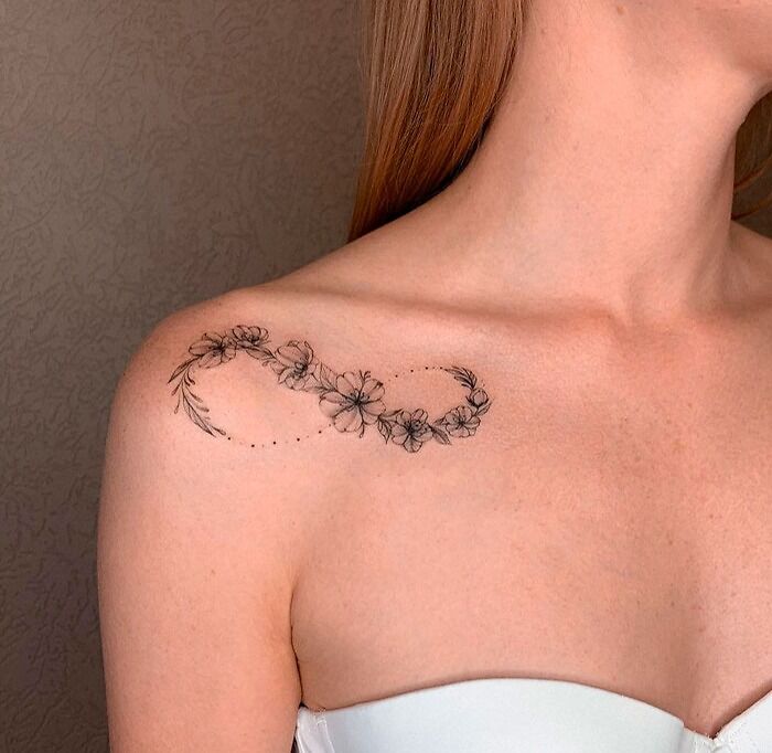Floral infinity tattoo on shoulder, symbolizing eternal creativity and beauty.