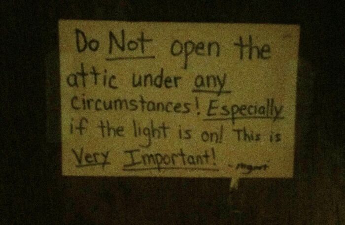 Handwritten sign warning not to open the attic under any circumstances, featured in a weirdest pics online group.