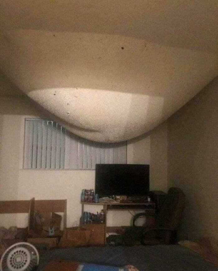 Ceiling swollen and sagging in a bedroom, showcasing one of the weirdest pics from an online group collection.