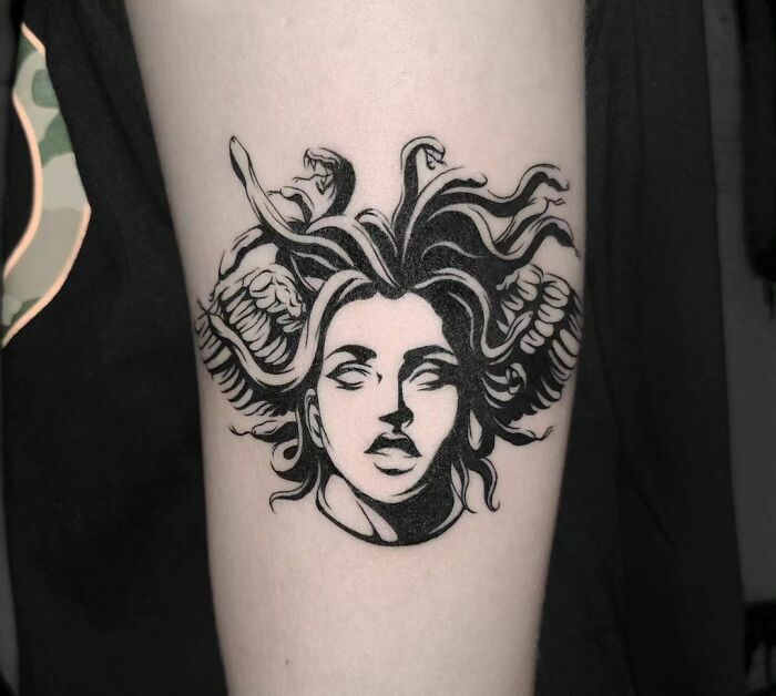Medusa-inspired mental health tattoo in black ink on an arm, featuring snakes as hair, symbolizing strength and healing.