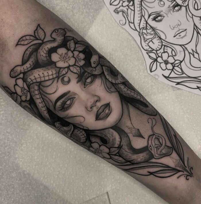 Medusa-inspired mental health tattoo, featuring snakes and floral elements on a forearm.