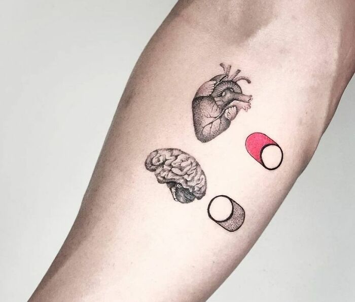 Detailed mental health tattoo featuring a heart, brain, and on and off buttons on an arm.