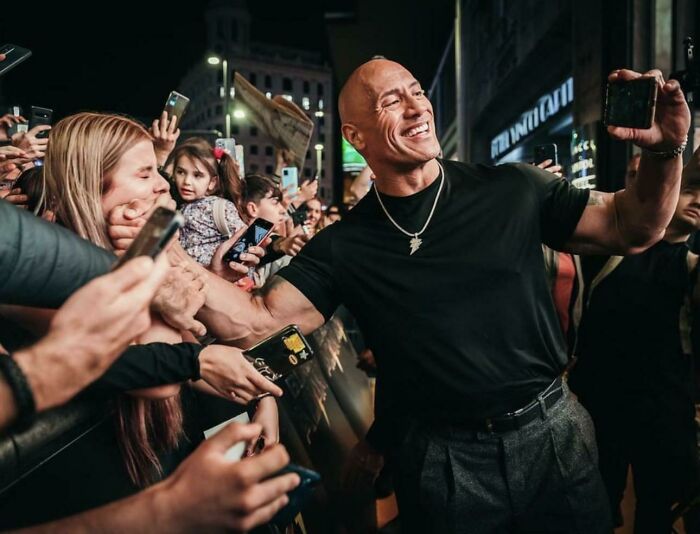 The Rock Taking A Selfie Of Himself Gleefully Backhanding A Fan