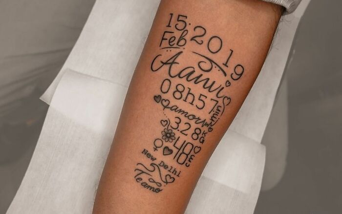 Tattoo with date, name, time, and birth details, honoring family.