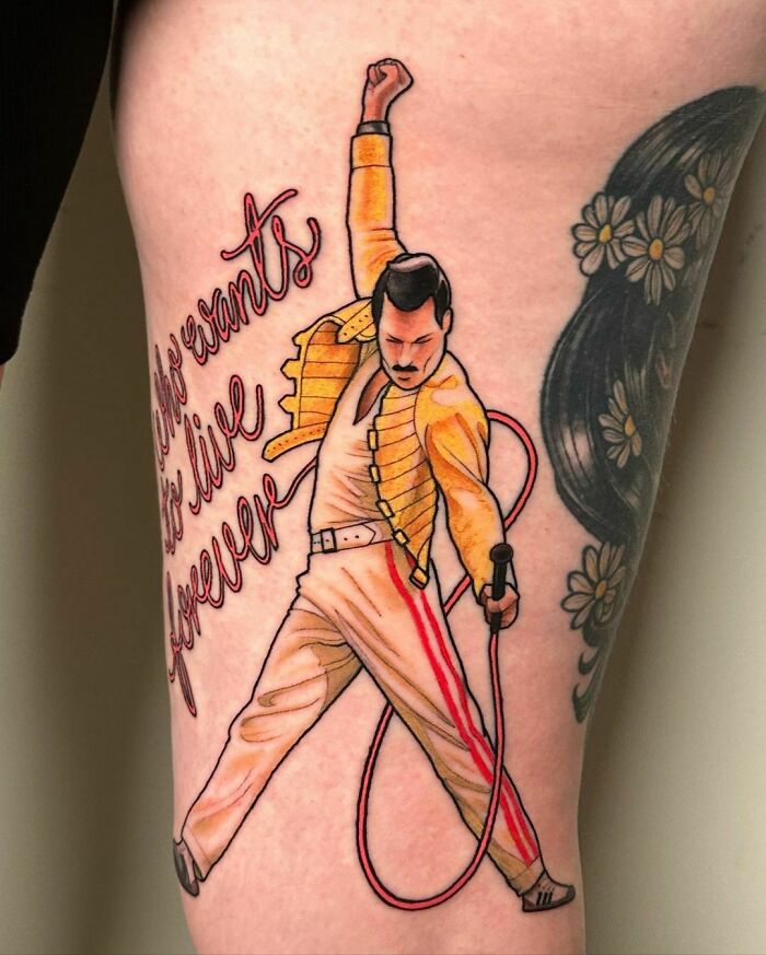 Music tattoo featuring iconic performer in a yellow jacket and white pants, with "Who wants to live forever" text.
