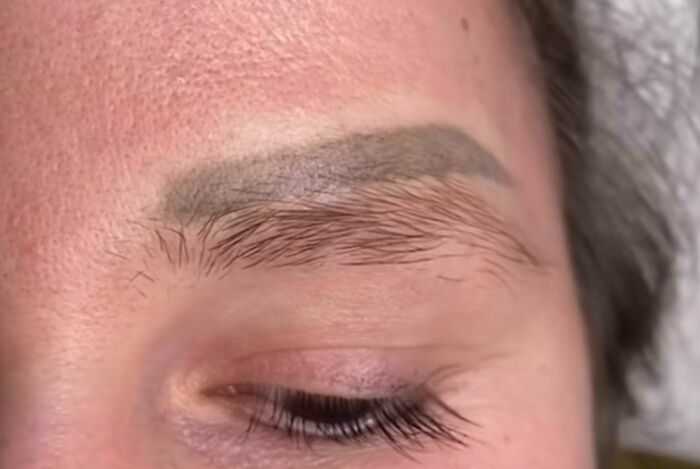 Eyebrow tattoo faded over natural brow hair, illustrating a common ink mistake people tend to make permanently.