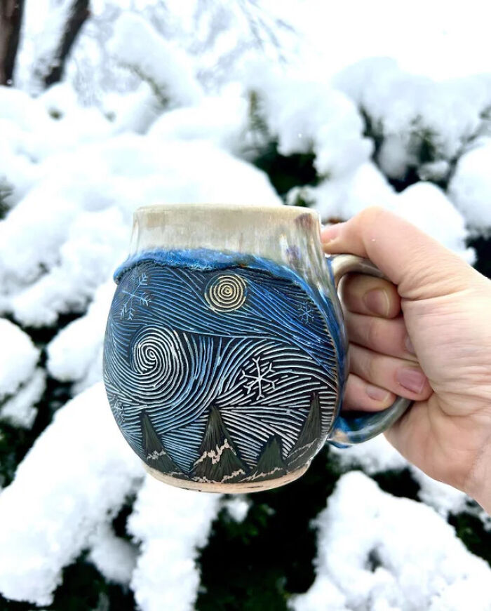 Hand holding a detailed winter-themed mug with swirling night sky design, perfect example of creative mug life use.