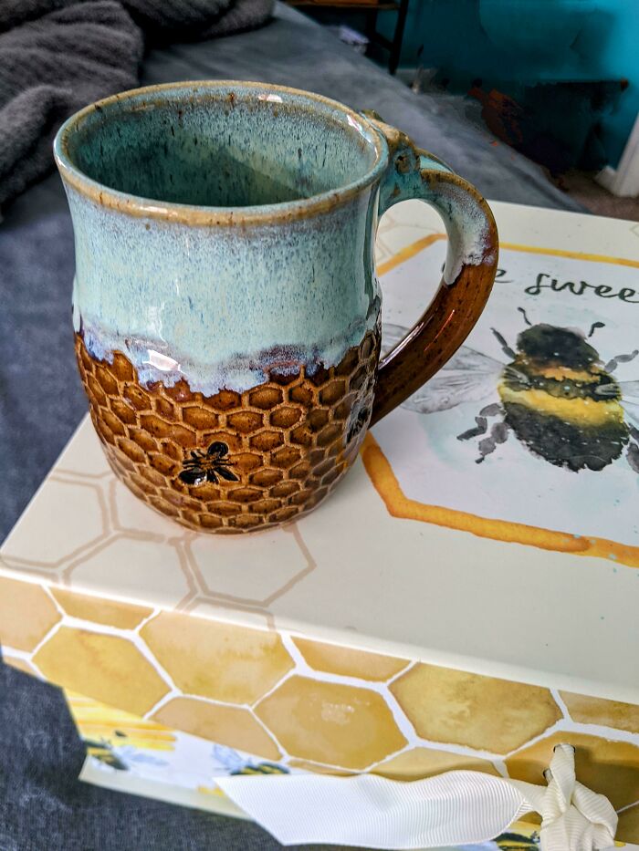 Ceramic mug with honeycomb texture and bee design, showcasing creative mug life with artistic and functional details.