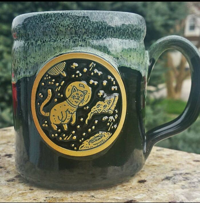 Ceramic mug with space-themed cat and pizza design, showcasing creative mug life beyond typical use.