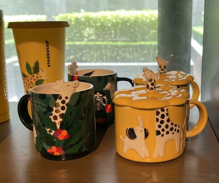 Colorful animal-themed mugs including giraffe and elephant designs displayed on a shelf, showcasing mug life creativity.
