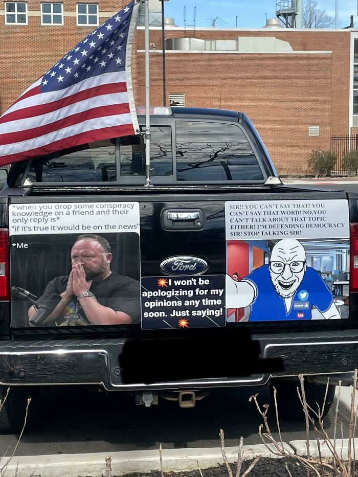Truck tailgate with an American flag and humorous bumper stickers, creating an embarrassing image.