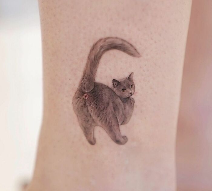 Unusual cat tattoo design on skin, raising questions about its thoughtfulness in e*******n.