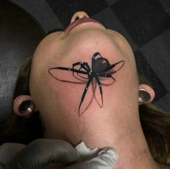 Spider tattoo on a person's neck, highlighting tattoos with unexpected placements.