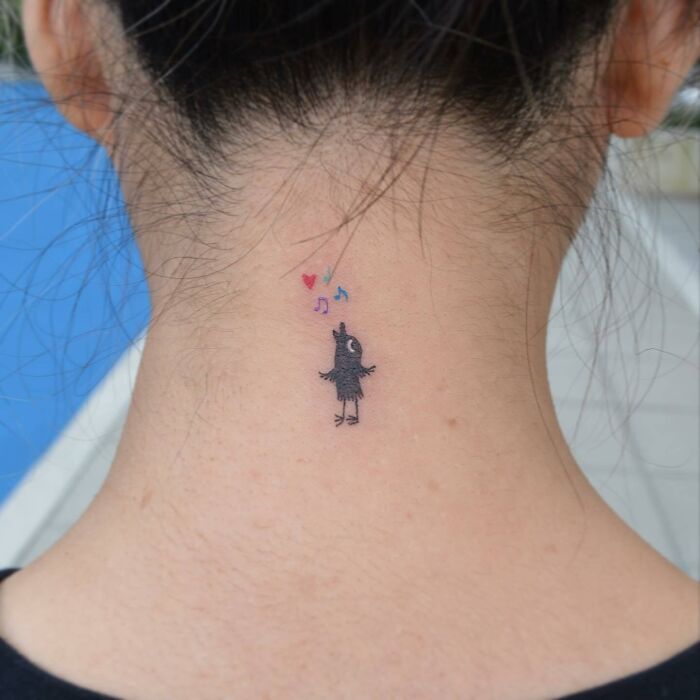 Bird music tattoo on the back of the neck with colorful notes and hearts floating above.
