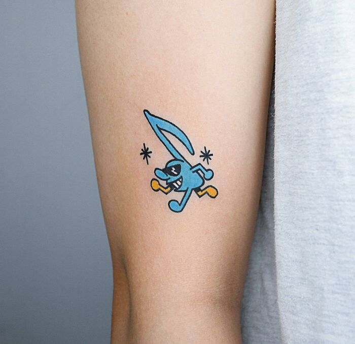 Colorful cartoon character music tattoo on arm.