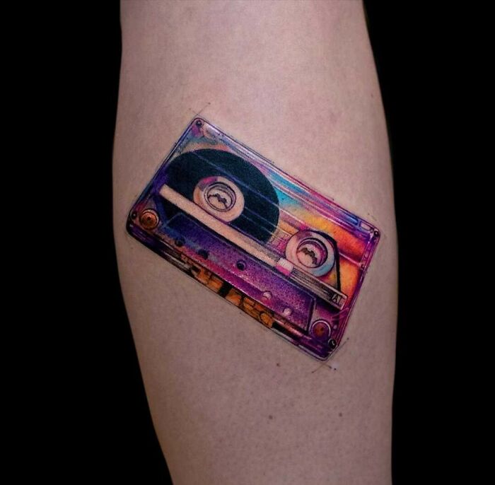 Colorful cassette tape music tattoo on a forearm.