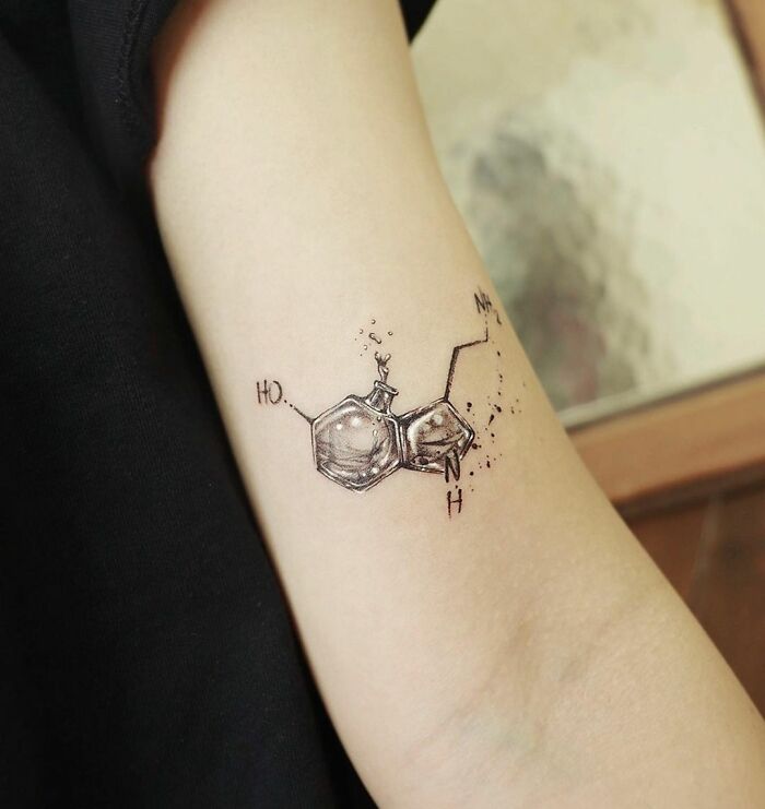 Science tattoo of a molecular structure on an arm, showcasing detailed chemistry design.
