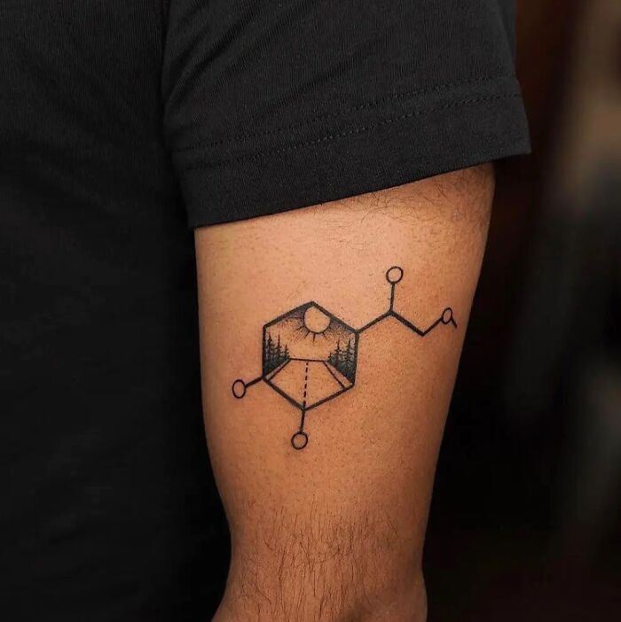 Tattoo of a chemical structure with landscape design, representing scientific imagery on a person's arm.