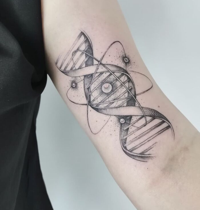 DNA science tattoo featuring atomic orbit design on a forearm.
