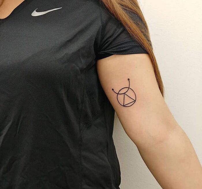 Minimalist zodiac tattoo on a woman's arm, featuring geometric shapes, symbolizing unique astrology style.