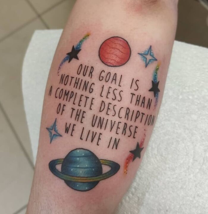 Science-themed tattoo featuring planets, stars, and an inspirational quote about the universe.