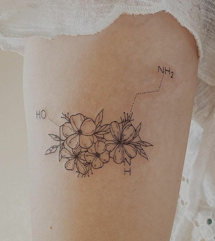Science tattoo featuring flowers with chemical structure elements on skin.