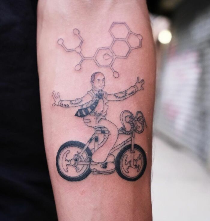 Science tattoo featuring a person on a bike with molecular structure above.