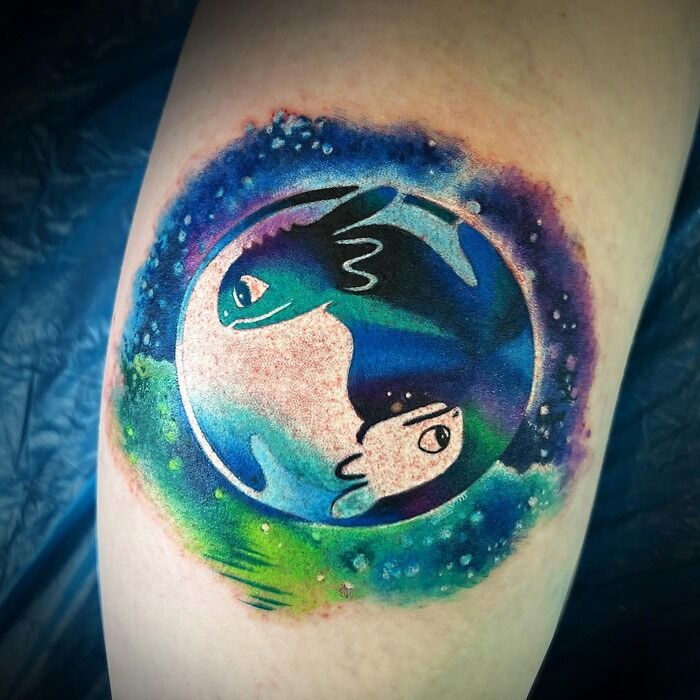 Colorful yin yang tattoo featuring abstract dragon design with cosmic background.