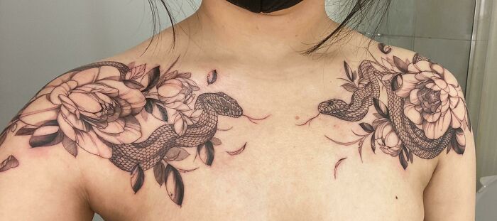 Snake tattoo design with floral elements on shoulders and chest.