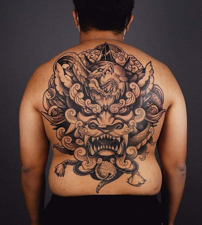Back with an intricate snake tattoo design, showcasing a detailed mythical creature motif.