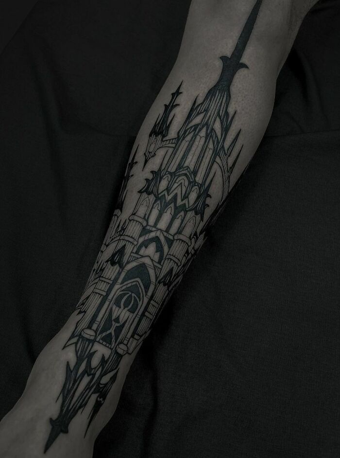 Gothic tattoo of a detailed cathedral design on forearm, showcasing intricate black ink artistry.