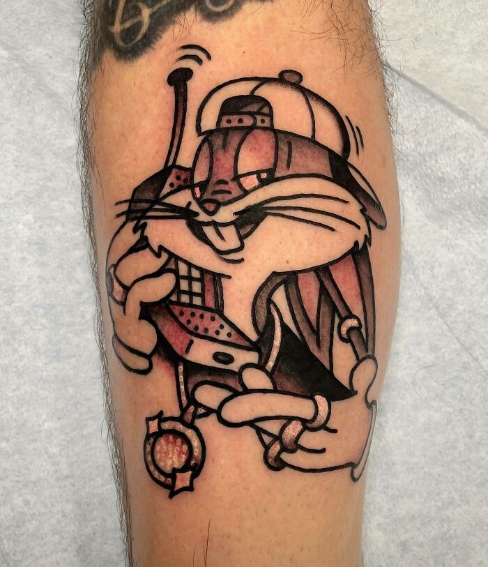 '90s tattoo featuring a cartoon character with a vintage cell phone, showcasing the decade's cultural nostalgia.