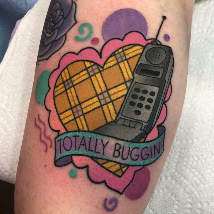 '90s tattoo featuring a plaid heart, vintage cellphone, and "Totally Buggin'" text.