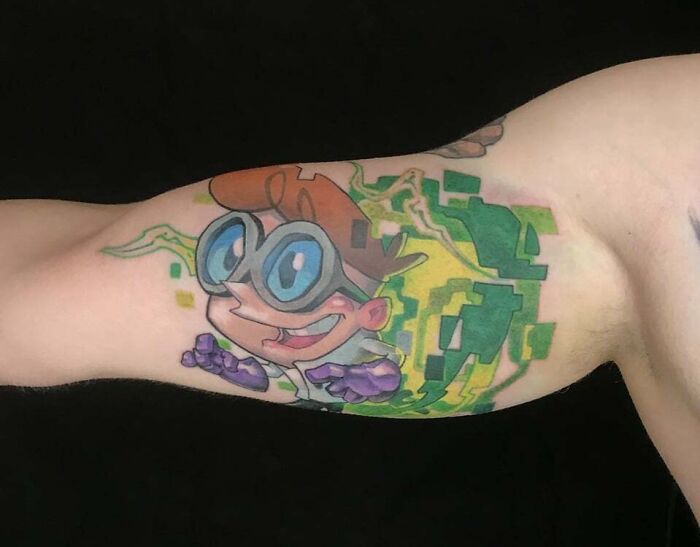 Cartoon tattoo on arm showcasing '90s culture with colorful design.