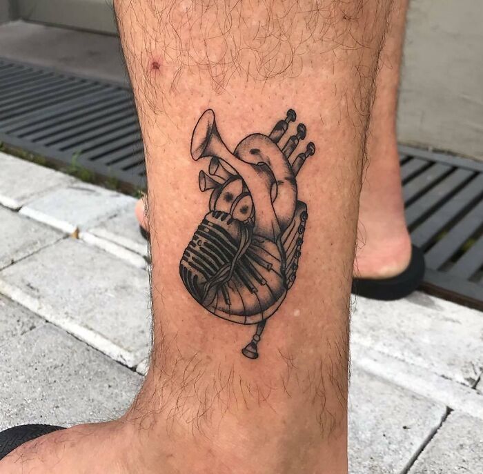Unique music tattoo of a trumpet and heart on a person's leg, showing creative expression through ink.