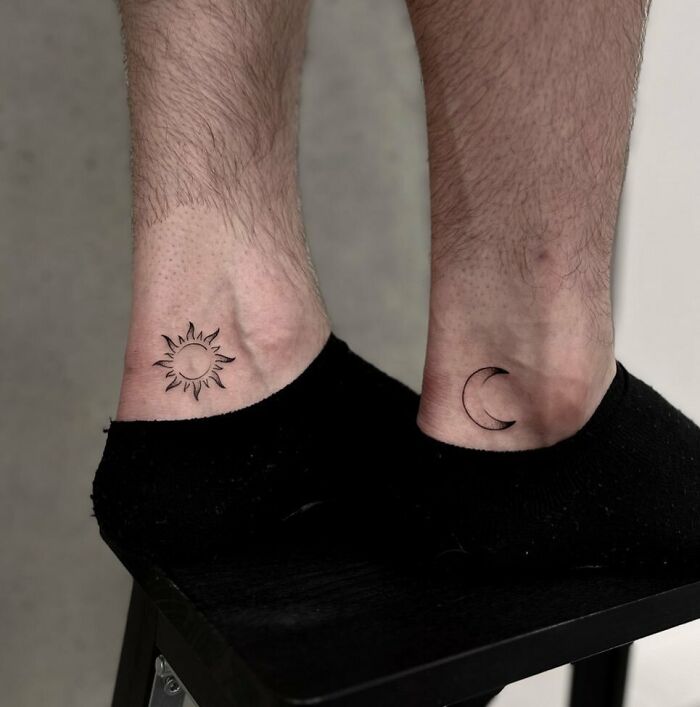 Ankle tattoos of a sun and moon on a person wearing black socks, featuring minimalist design.