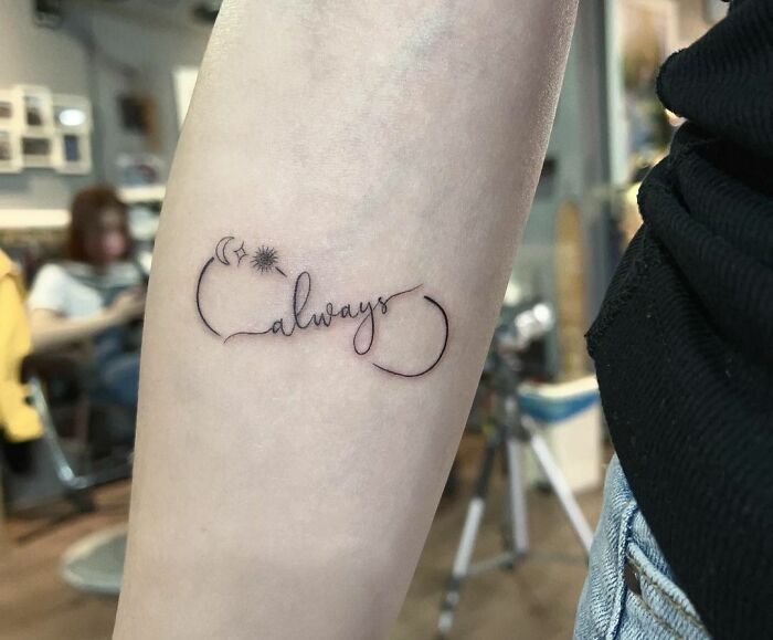 Infinity tattoo with "always" text and stars on an arm, showcasing eternal creativity.